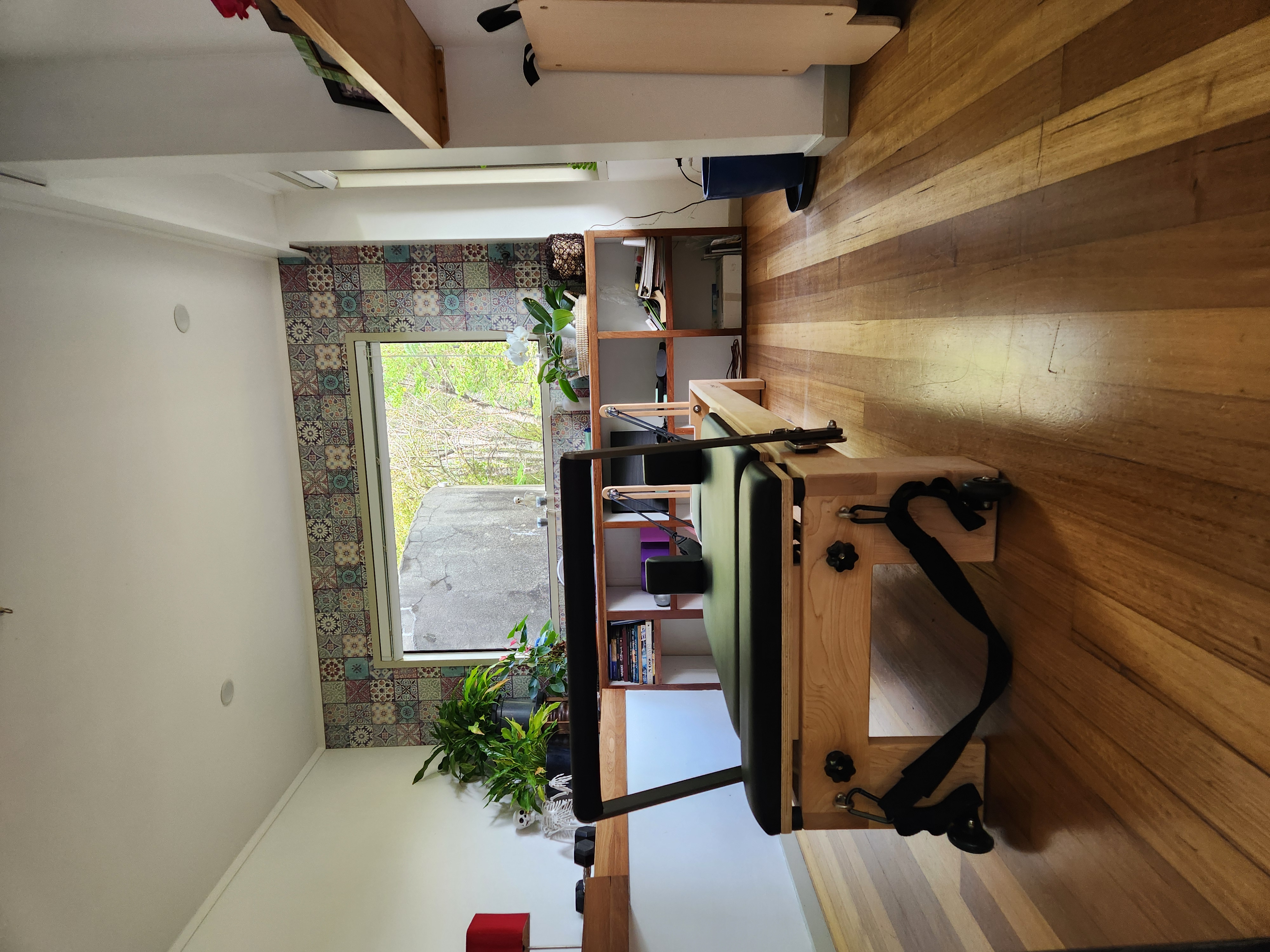 Pilates reformer studio with decorative tiled backsplash and natural light